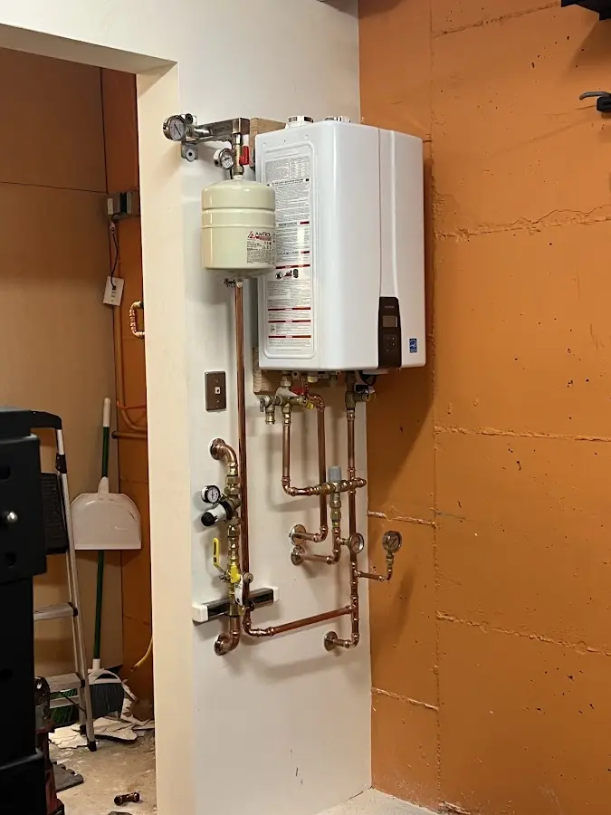 Plumbing technician inspecting water heater connections in Perris